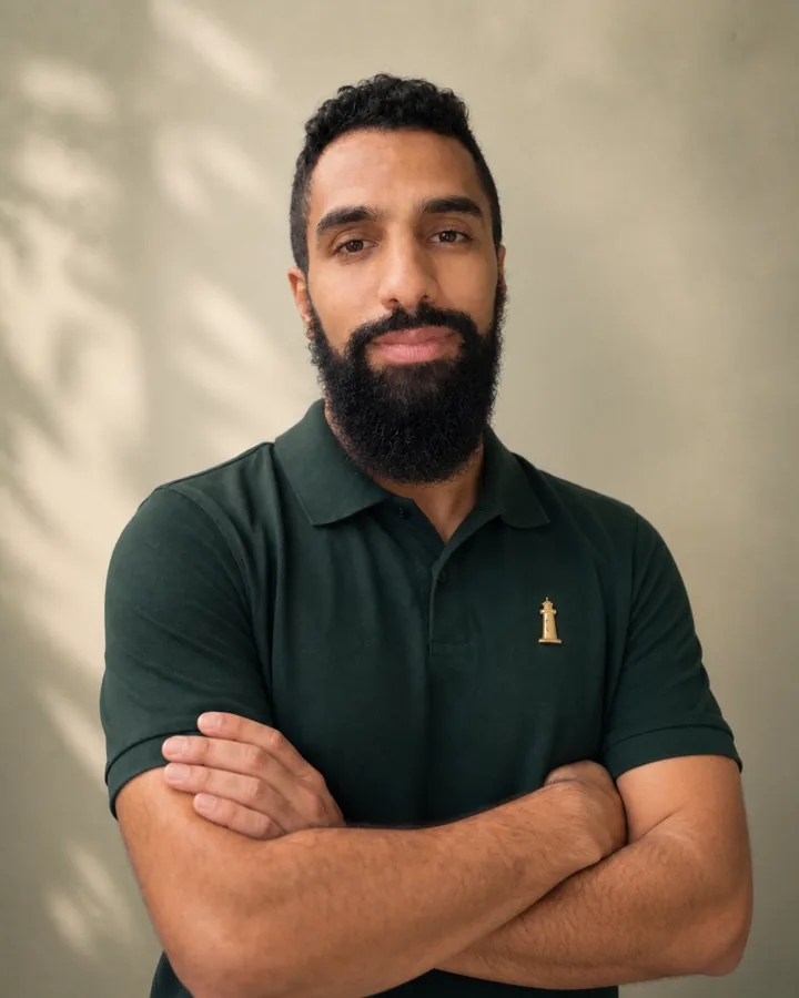 Profesor de Pathway con barba, polo verde y emblema del faro